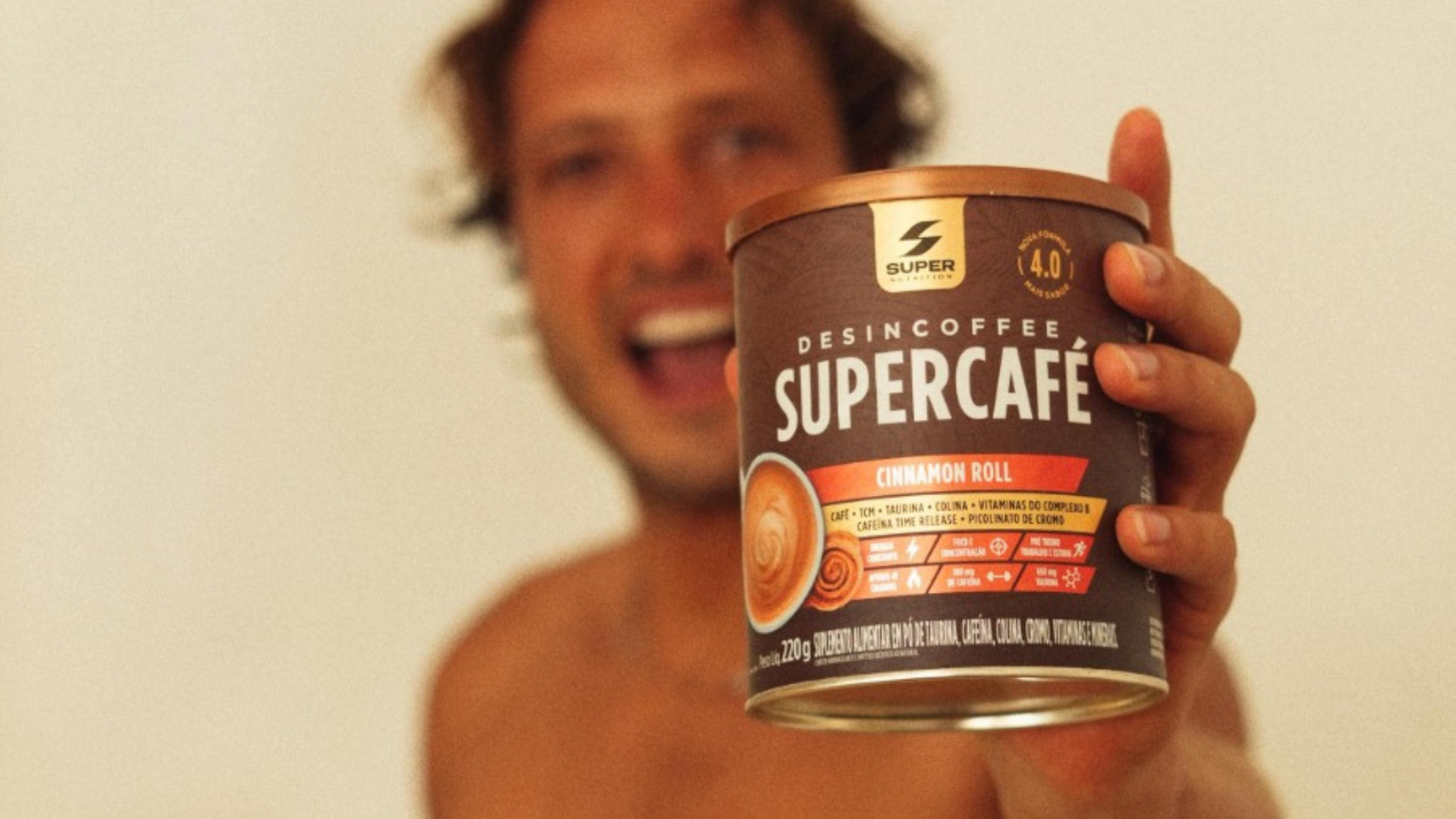 A man holdinh desincoffee performance coffee in his hand with a smile