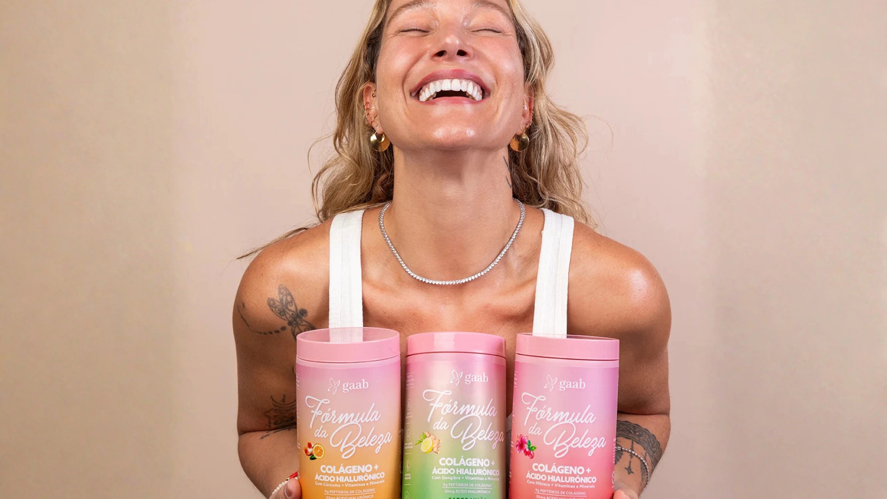 Woman holding three pink and orange Beauty Formula Collagen with a beige background. Cyber Monday Sale 2025 Australia