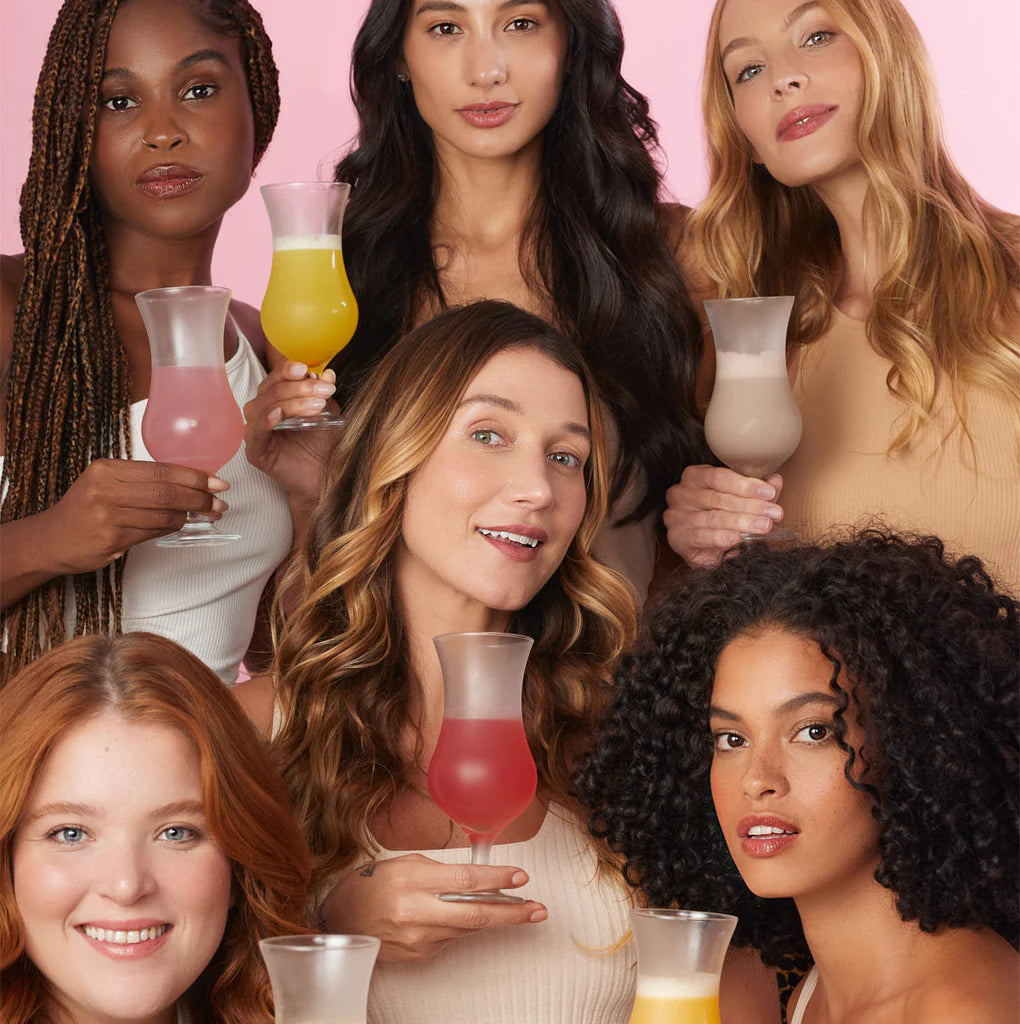 Diverse group of happy women enjoying colorful nutritional drinks, showcasing a variety of flavors, symbolizing inclusivity and wellness in beauty.