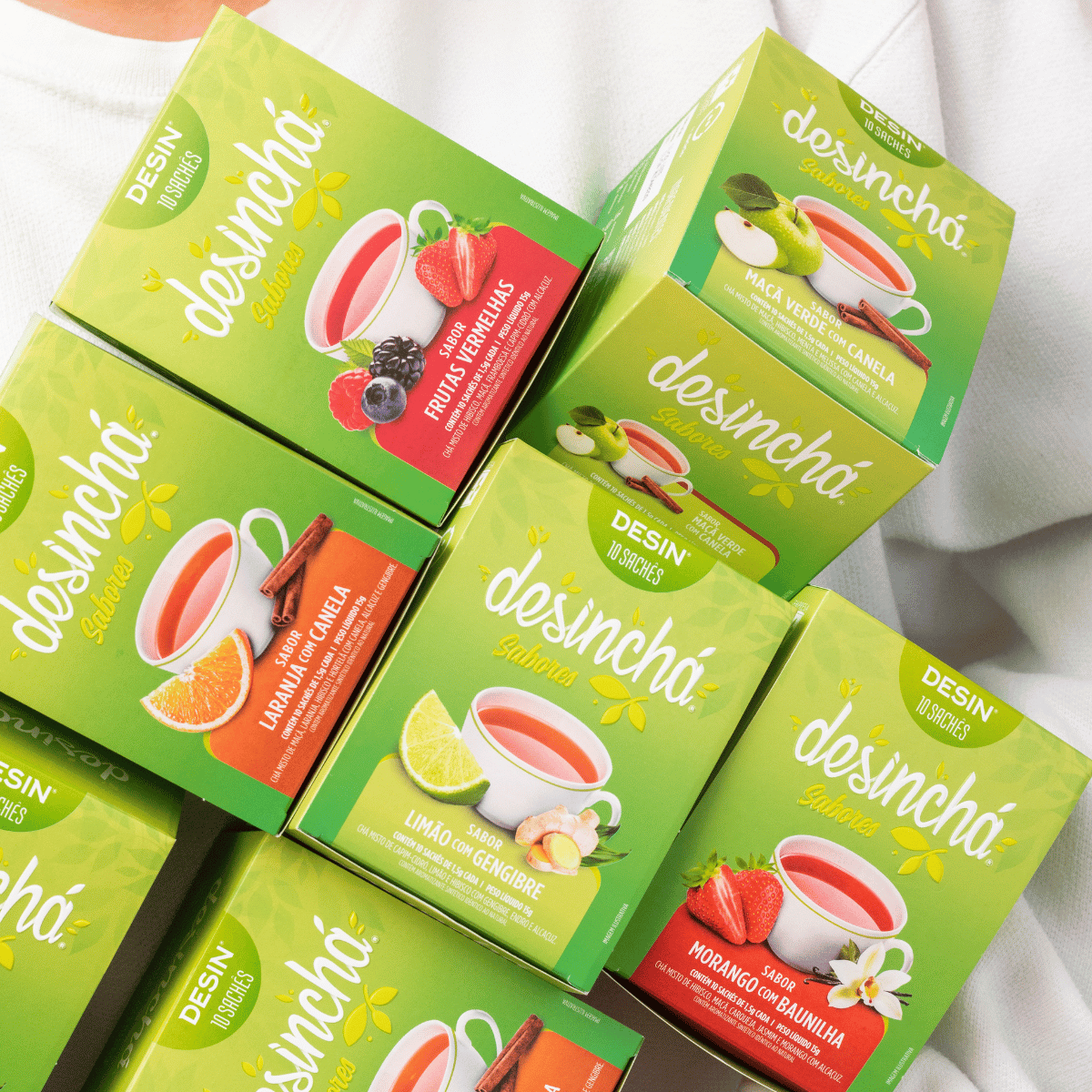 a woman holding boxes of desincha fruity detox tea in different flavours