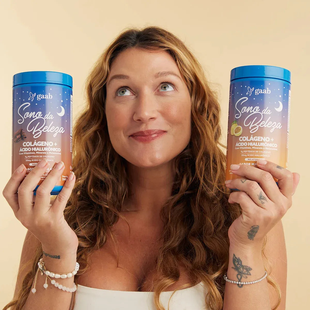 Smiling woman holding two containers of GAAB 'Sleep Beauty' Collagen+ with Hyaluronic Acid supplements, one chocolate-flavored and the other vanilla, anticipating the beauty benefits of the products.